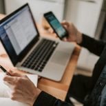 Small business website design team testing speed and mobile layout on phone and laptop